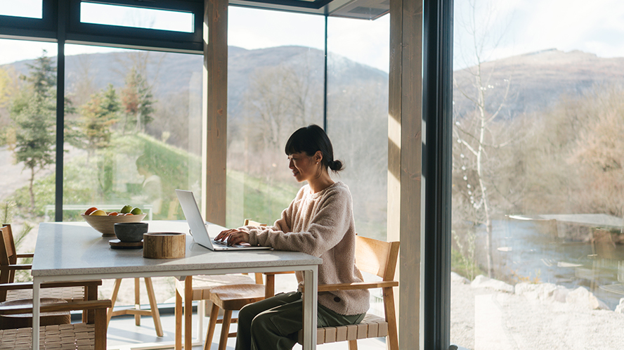 women at a desk viewing laptop
